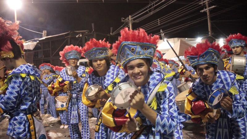 artistas se apresentam no sambódromo da cidade, fantasiados e com instrumento de percussão
